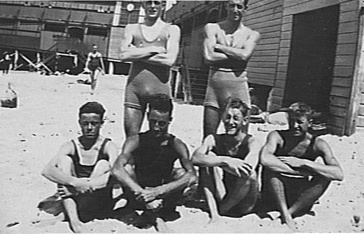 Six members of Manly Surf Club with the surf pavilion in the