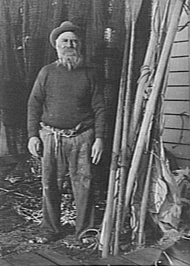 Unidentified elderly man in a boatshed