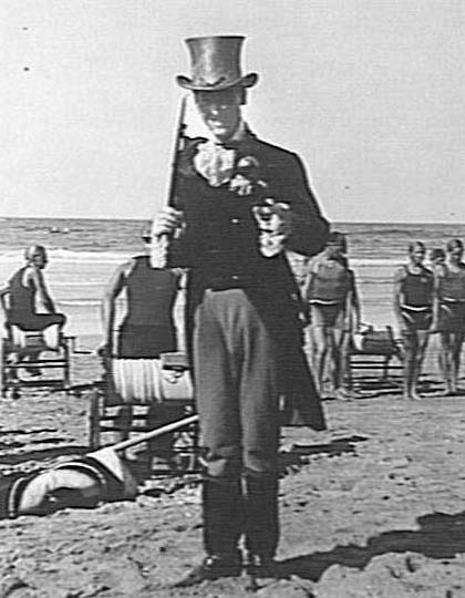 Portrait of unidentified man, wearing a top hat, Manly Beach