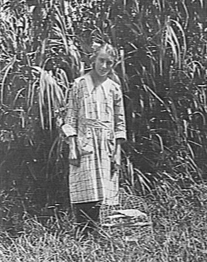 Portrait of a young girl with a caged galah