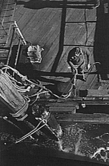 Wharf-hand hauling in guy rope as a Manly Ferry berths