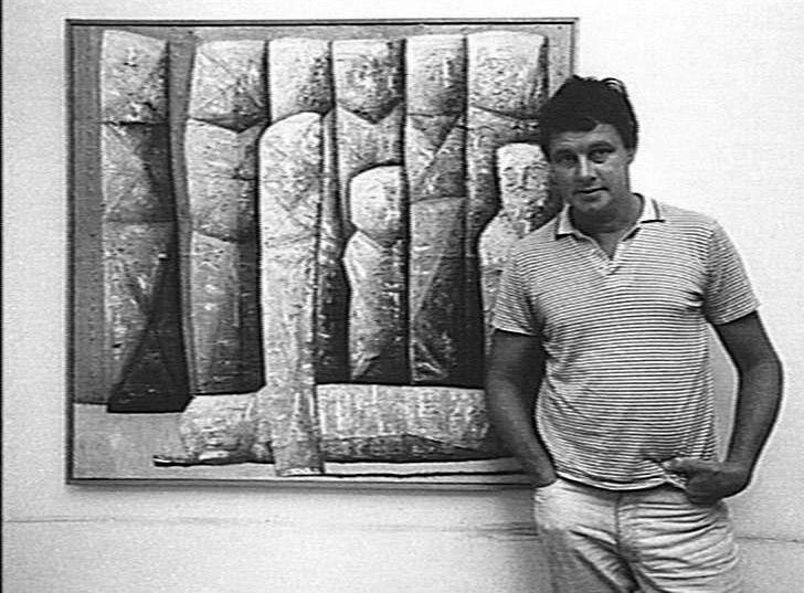 Keith Looby standing in front of one of his works, 1985