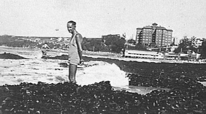 Unidentified man standing in seaweed, Manly Beach