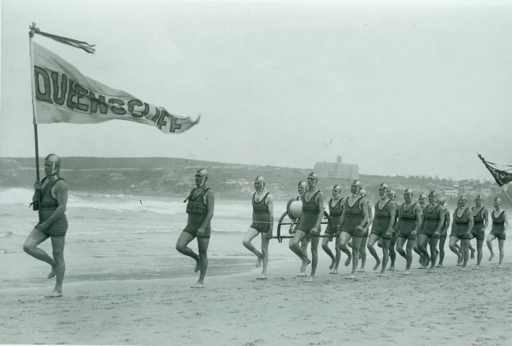 Surf carnival at North Steyne, Queenscliff Surf Life Saving Club's march past team