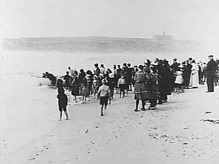 Crowd at Manly Beach watching a boat being launched, c1900