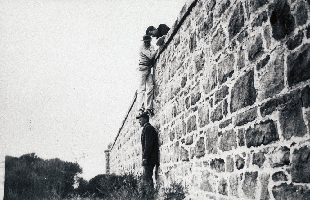 Men climbing the stone wall on North Head