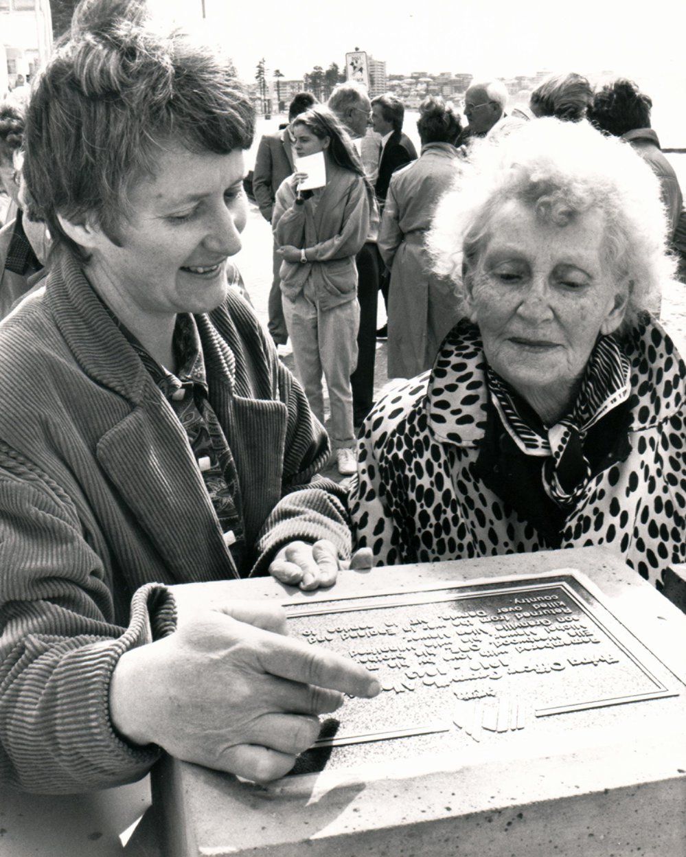 Barbara Murray and Ella Westwood inspecting a plaque, Manly