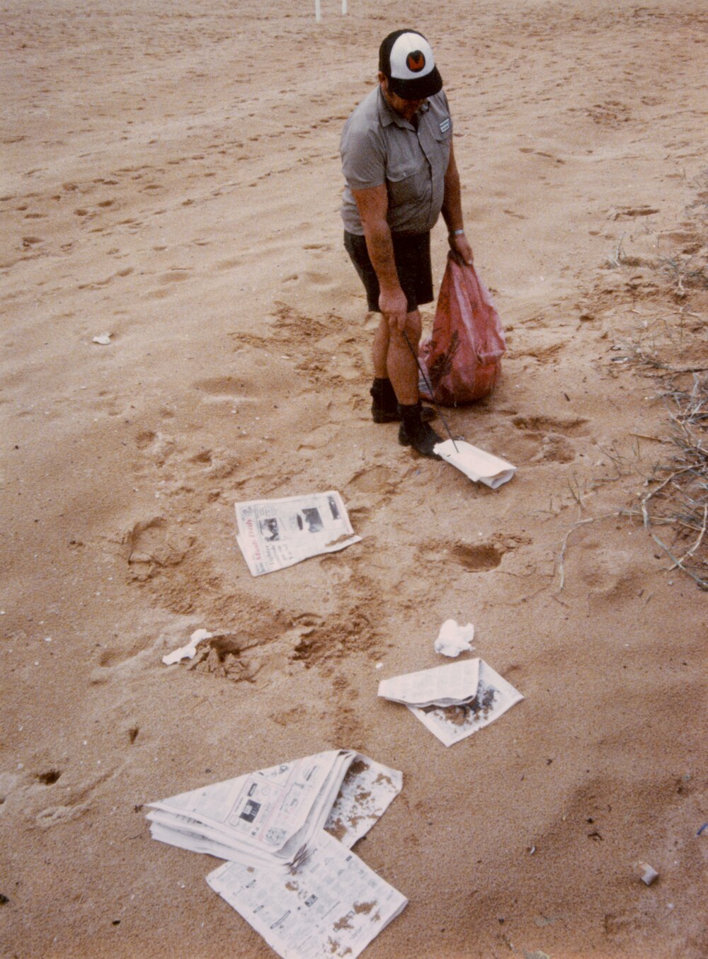 Warringah Council staff member collecting rubbish from the beach