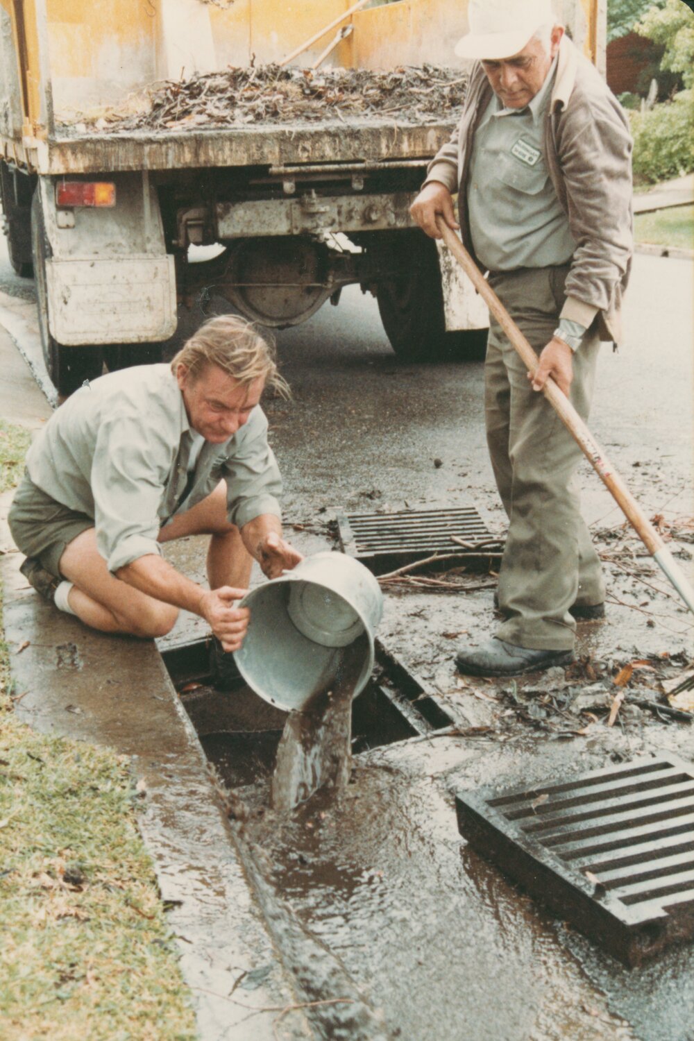 Warringah Council road workers clearing a blocked drain