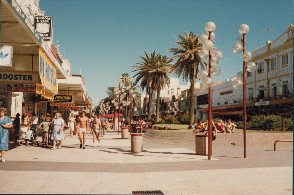 Pedestrians walking along The Corso, near the ocean end, Manly, 1980