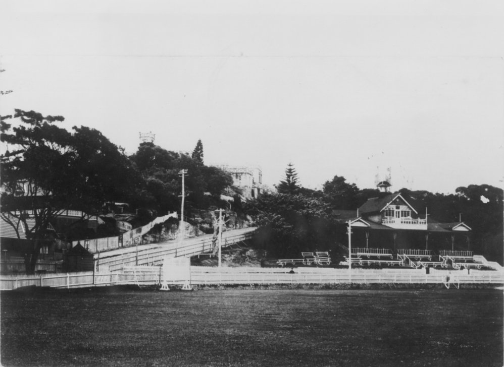 View looking west across Manly Oval, with the grandstand, Sydney Road and Dalley's Castle, Manly, pre 1939