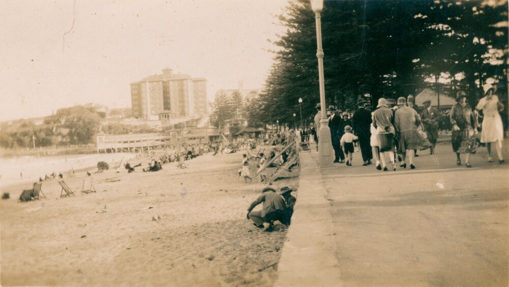 View south along Manly Beach, Manly, with crowds strolling along the esplanade, c1930s