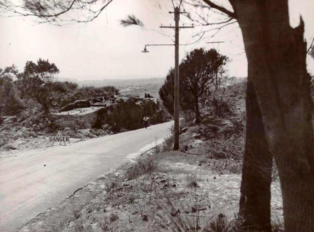 View down Frenchs Forest Road with sign reading danger, Seaforth, 7th October 1949
