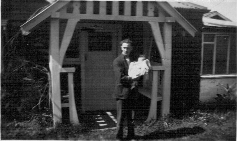 Mr Douglas holding baby June outside the family home in Mona Vale