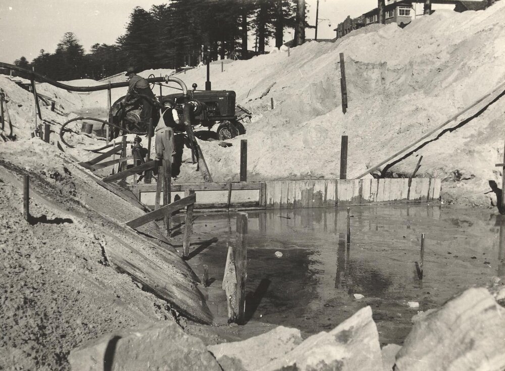 Work crew using water pump in channel duirn rebuilding of sea wall at North Steyne, Manly, 1955