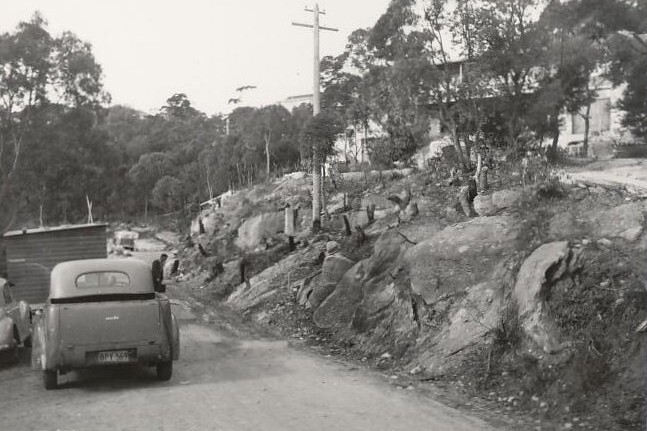 Peronne Avenue, rocky slope and vehicles, Clontarf, 1956