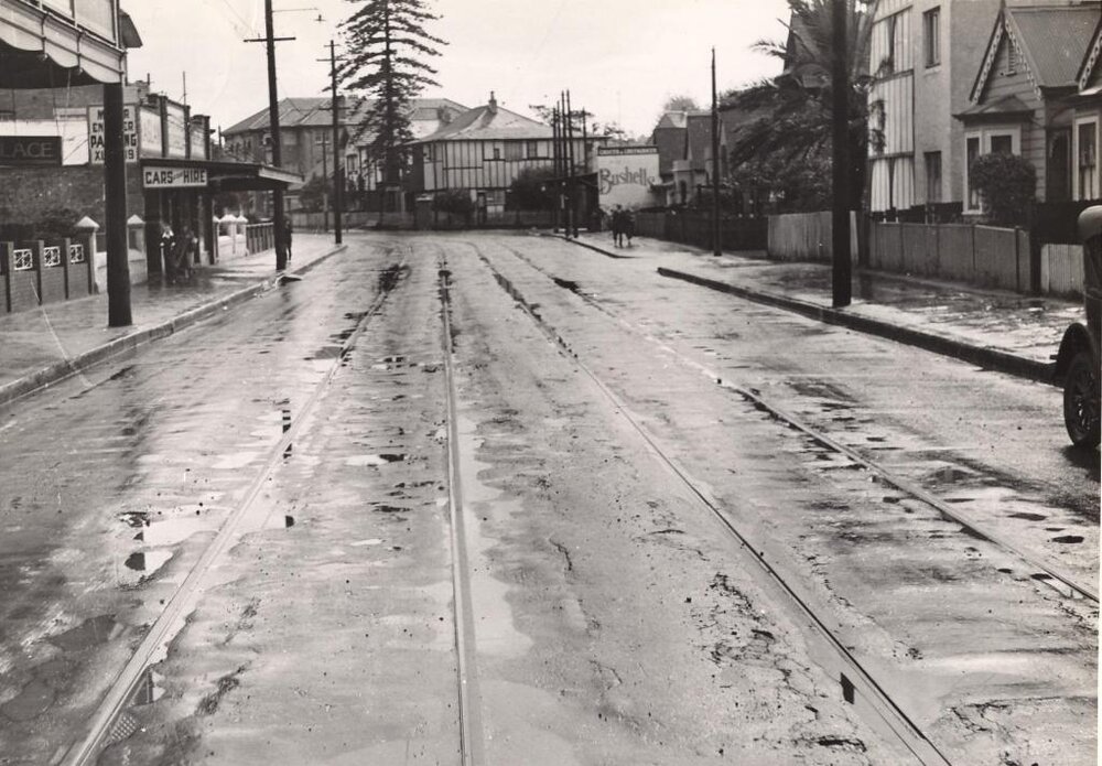 Pittwater Road near a bend and car hire shop, Manly, 29th April 1940
