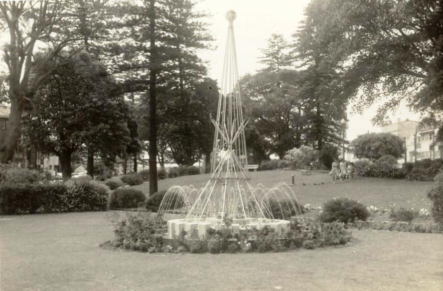 Rotary fountain in Gilbert Park, with women walking through the green, Manly, 1963