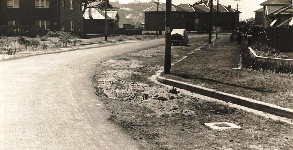 Unidentified street view with curb and maintenance hole, c1940s