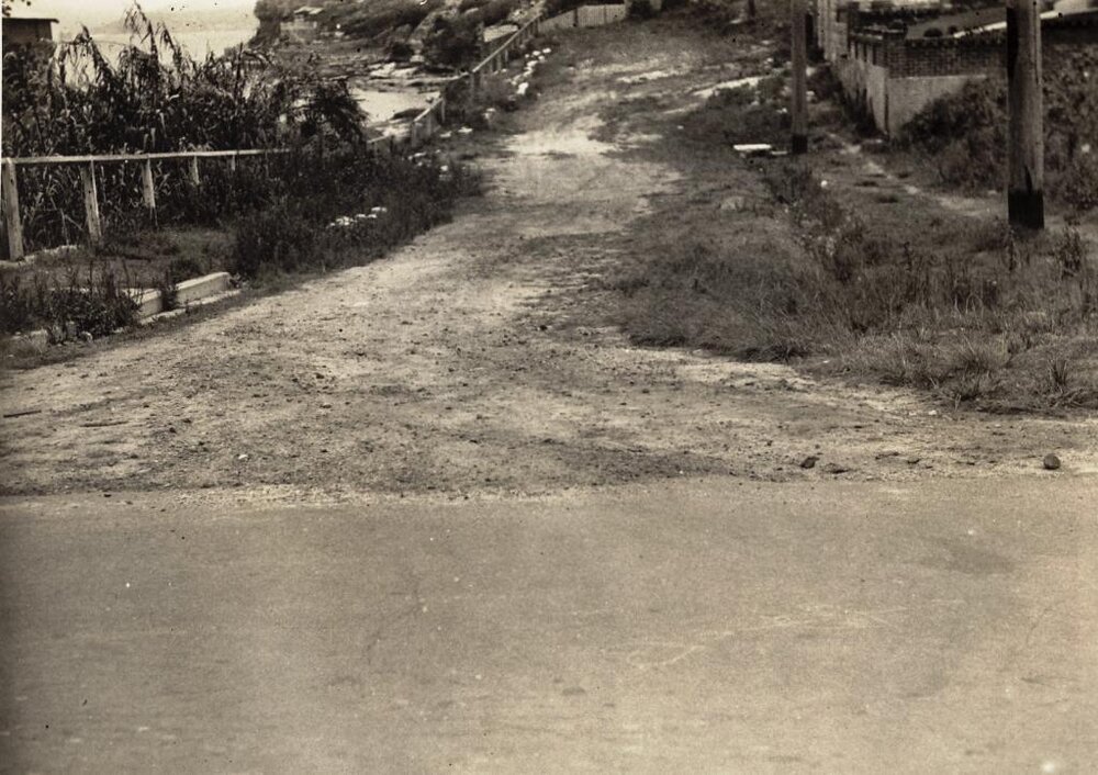 Unsealed section of roadway on unidentified street, c1940s