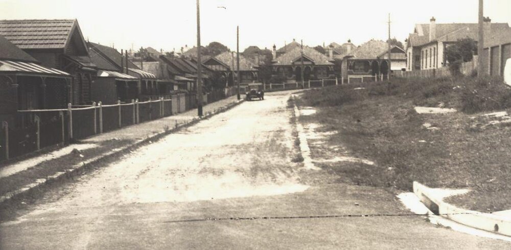 View of street with parked car and houses, c1940s