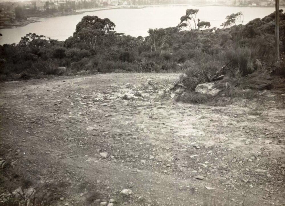 View over waterway from an unsealed roadbend, c1940s