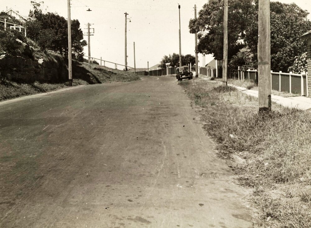 View of unidientified stretch of road with parked car, c1940s