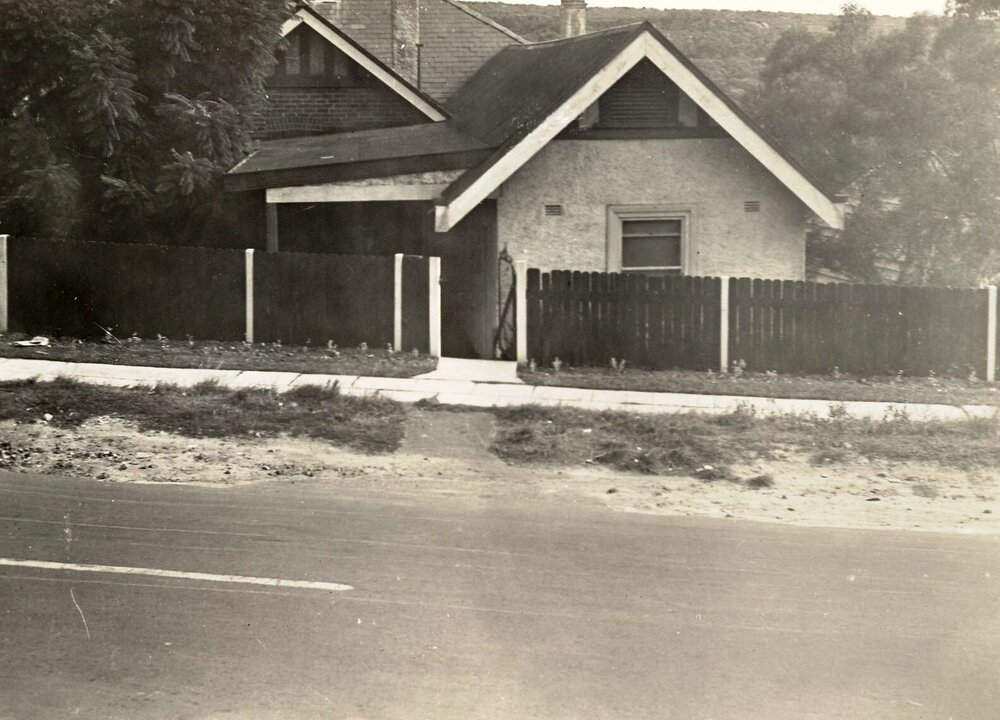 Unidentified street, view of house and fence from the road, c1940s