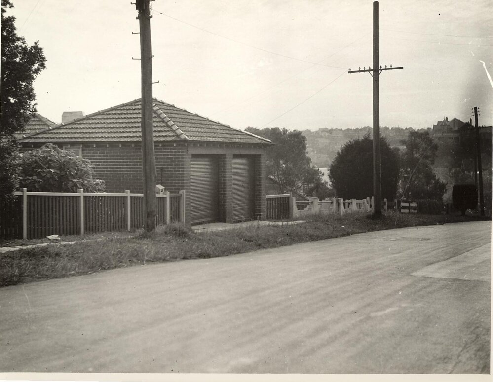 Streetscape with view of brick double garage from unidentified road, c1940s