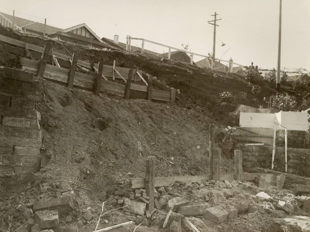 Earthworks continue on steep slope with timber supports, c1940s
