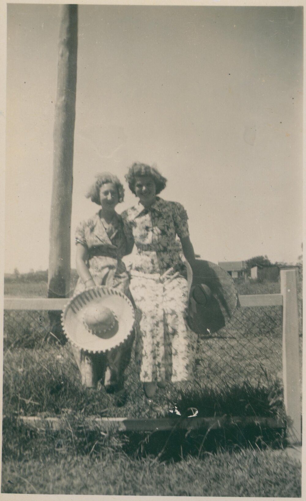 Two women sitting on a fence, Narrabeen, 1943