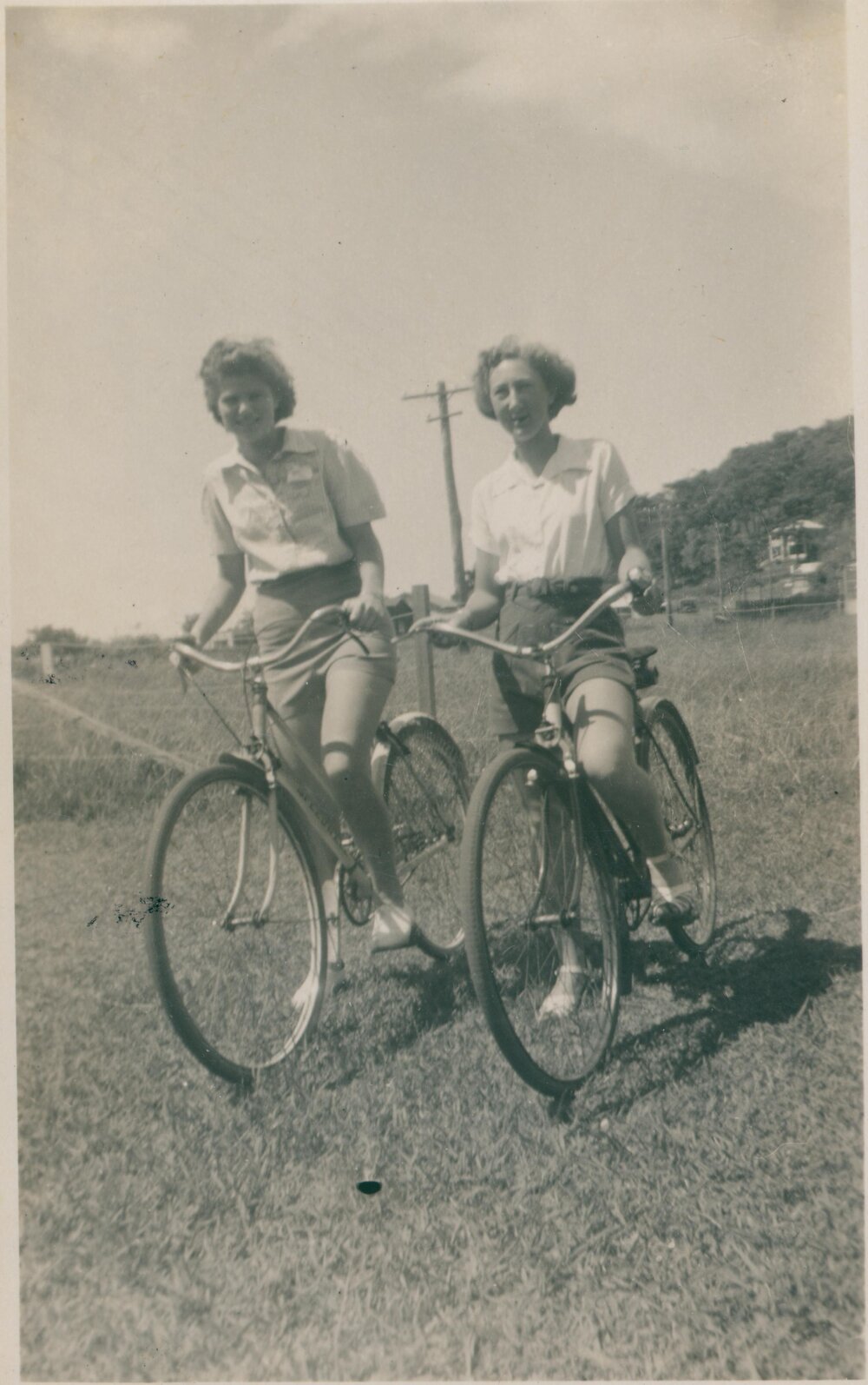 Two women riding bicycles, Narrabeen, 1943