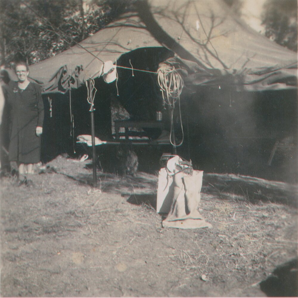 Nana Gill standing in front of tent on block of land, Scotland Island