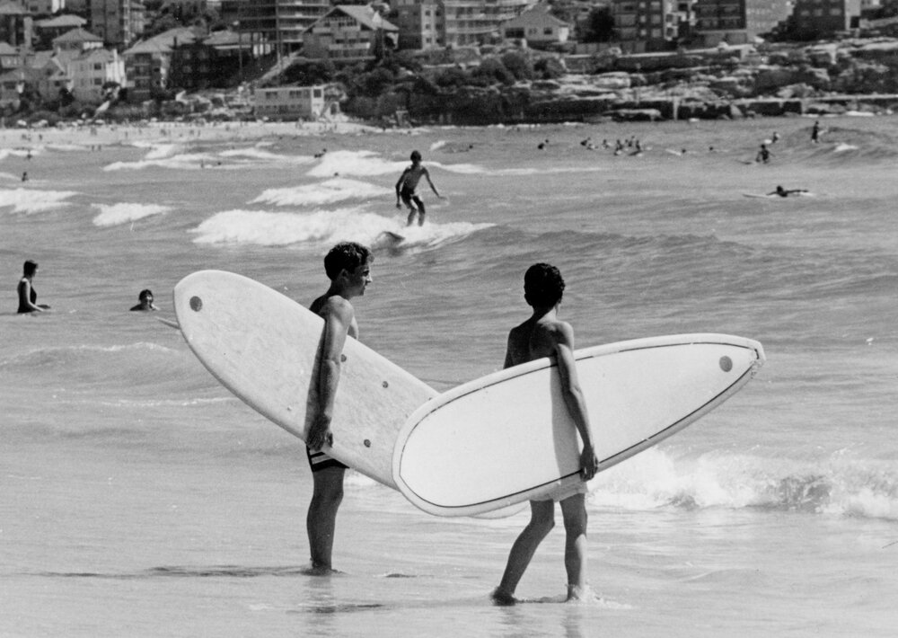 Two surfers about to enter the surf at Manly Beach, Manly, c1967-1973