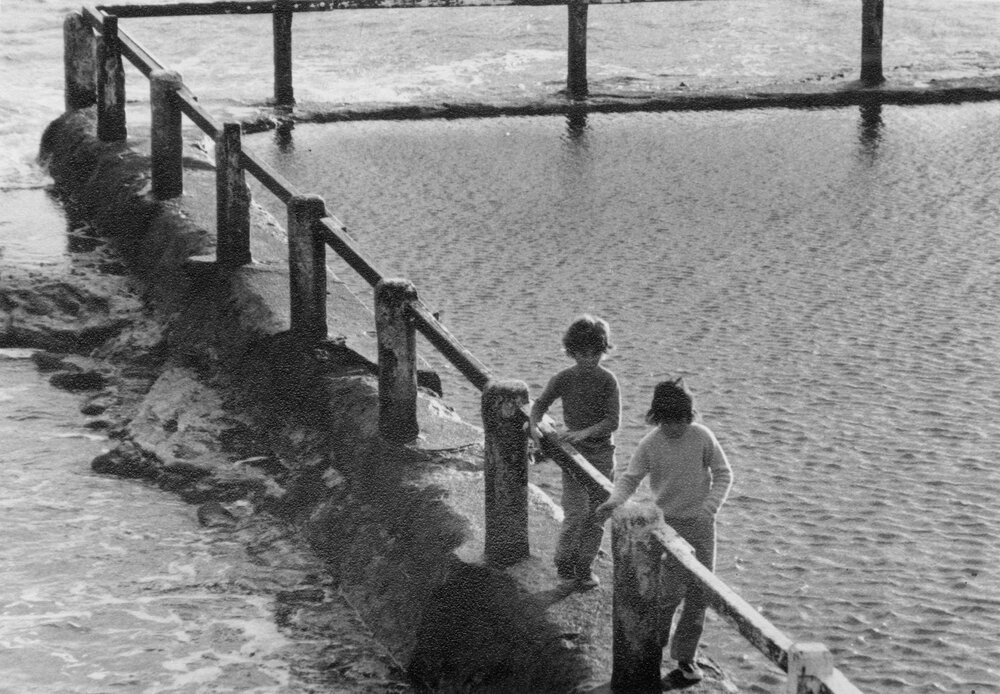 Two children walking along the edges of a rockpool, c1967-1973