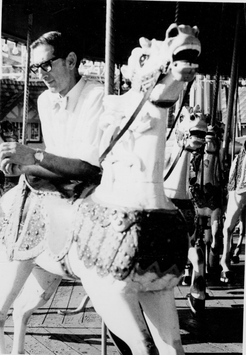 Man leaning over a horse on the carousel at Manly Fun Pier, Manly, c1967&ndash;1973