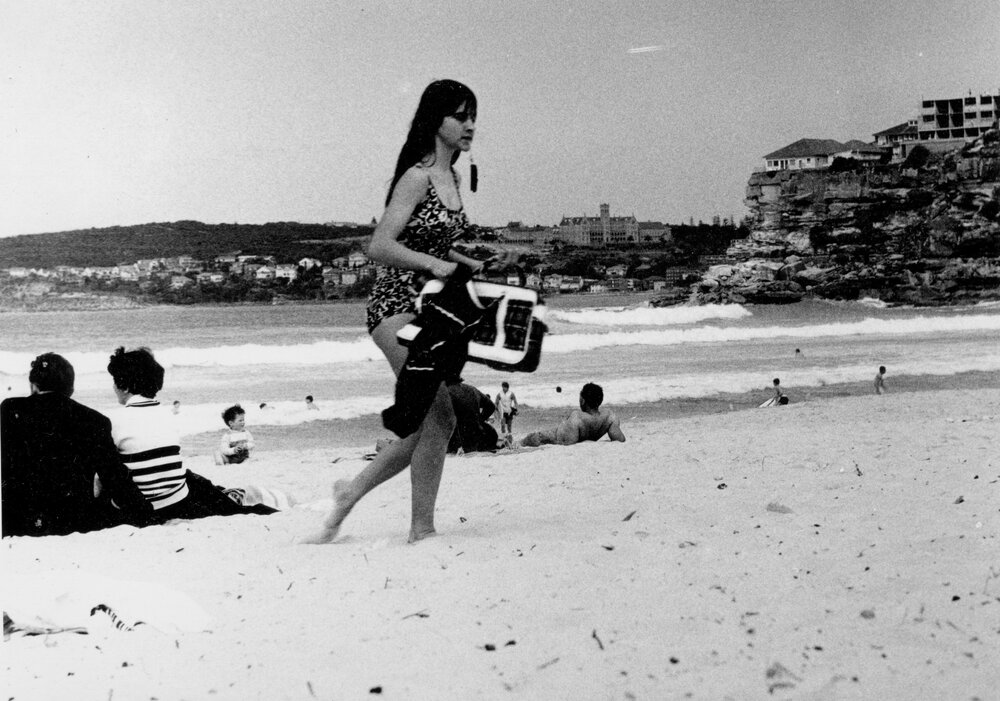 A woman walking across the Manly beach at South Steyne, Manly,  c1967&ndash;1973