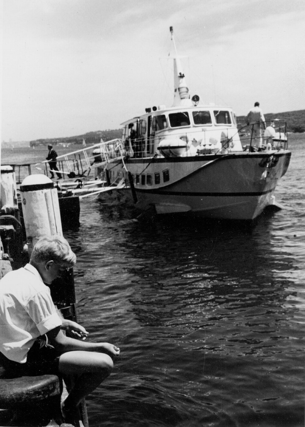 Boy fishing on the Manly Wharf in front of a hydrofoil, Manly, c1967&ndash;1973