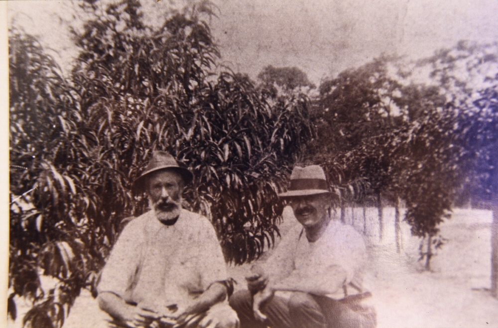 Isaac Larkin and another man sitting in the orchard on Isaac's Waratah Farm, Ingleside