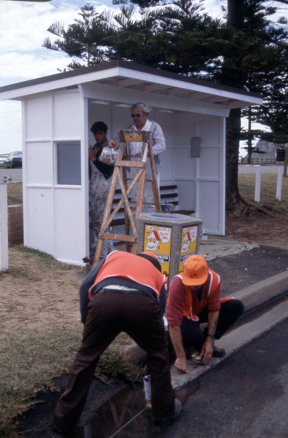 Warringah Council maintenance worker painting bus shelter at Newport