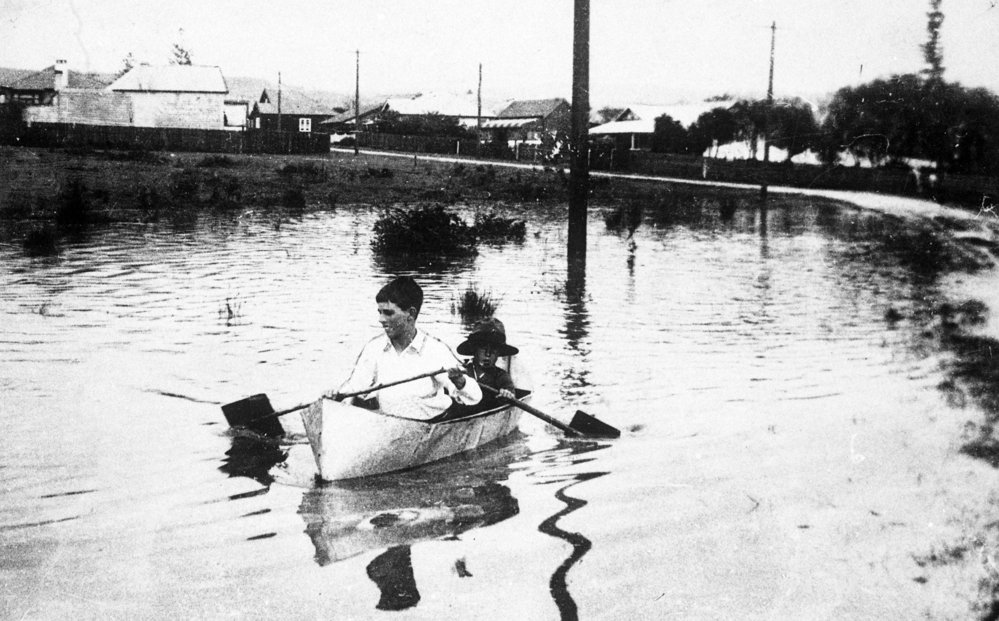 Vic Evans in boat in flood, William Street, Brookvale