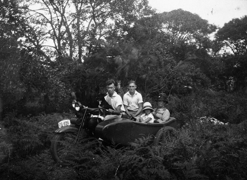 Maclean family on motorcycle in yard of home at Corrie Road, North Manly