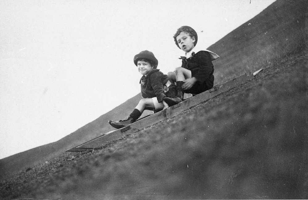 MacLean children riding a toboggan at Long Reef