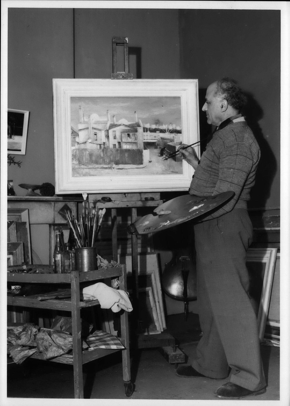 Sali Herman puts the finishing touches to a Woolloomooloo street scene, showing the back entrance to his studio.