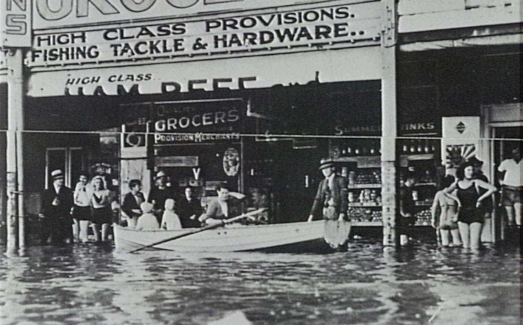 People in boat outside grocer shop during flood, Narrabeen, 1942