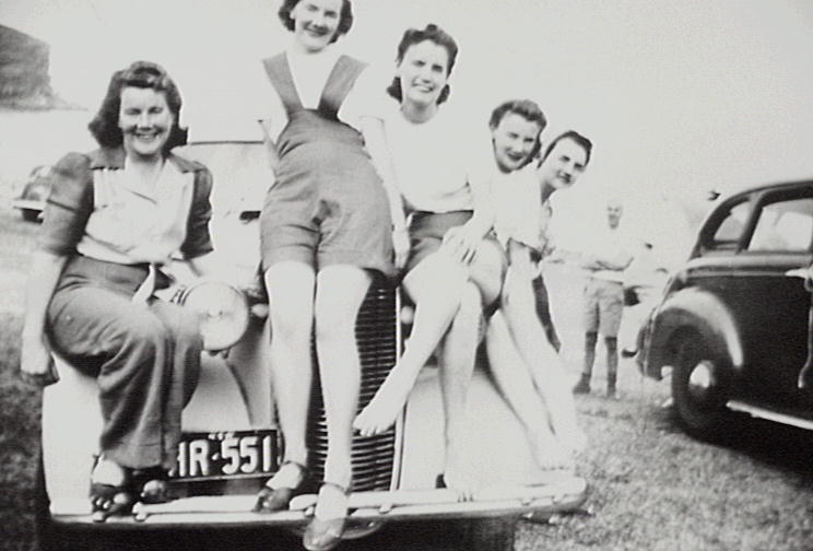 Dorothy Groom and friends sitting on bonnet of car at Bilgola Beach