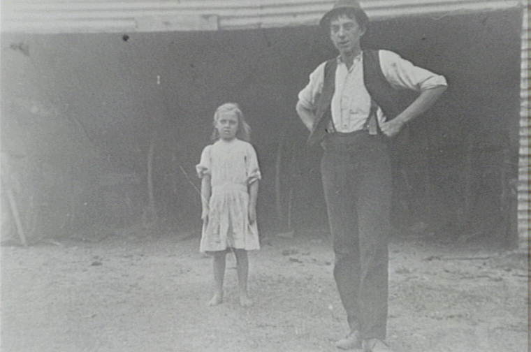 Eva and Arthur Larkin standing near shed on Waratah Farm, Ingleside. 