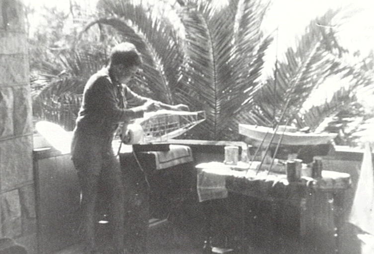 Laurie Seaman working on balsa wood plane fuselage on lower verandah of 153 Pacific Road, Palm Beach. 