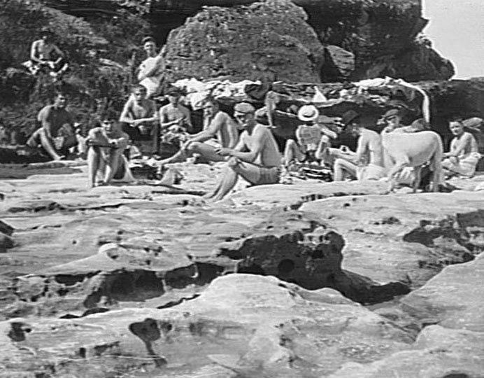 Bathers at Freshwater Beach sitting on rocks | Northern Beaches Council