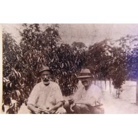 Isaac Larkin and another man sitting in the orchard on Isaac's Waratah Farm, Ingleside